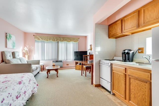 kitchen featuring white gas stove, light colored carpet, light countertops, decorative backsplash, and a sink