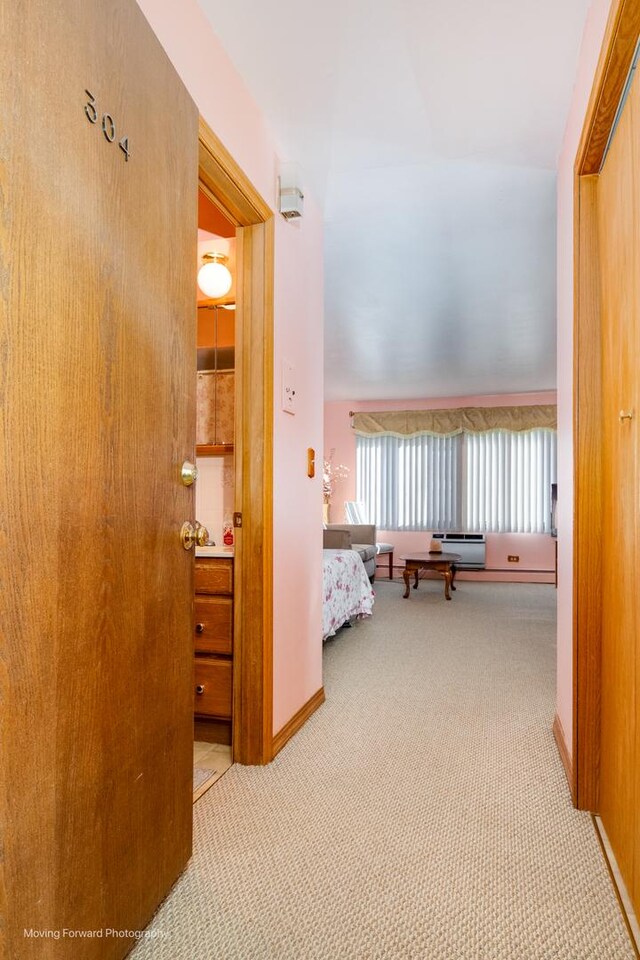 hall featuring baseboards and carpet flooring