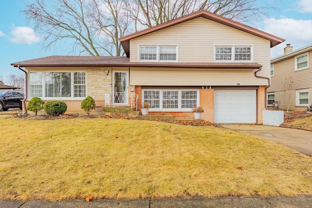 tri-level home with brick siding, an attached garage, driveway, and a front lawn