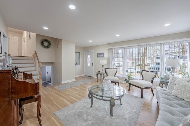 living room with baseboards, stairway, recessed lighting, and light wood-style floors