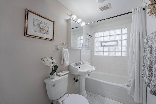 full bath featuring toilet, visible vents, and shower / bath combo with shower curtain