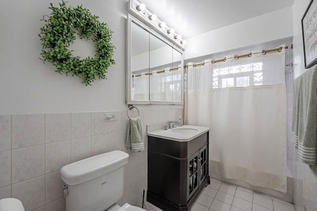 bathroom with shower / bath combo, toilet, tile patterned floors, vanity, and tile walls