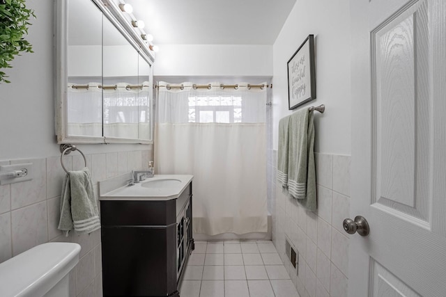 bathroom featuring toilet, visible vents, tile walls, tile patterned floors, and shower / bath combination with curtain