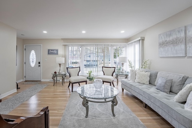 living room featuring baseboards, recessed lighting, and light wood-style floors