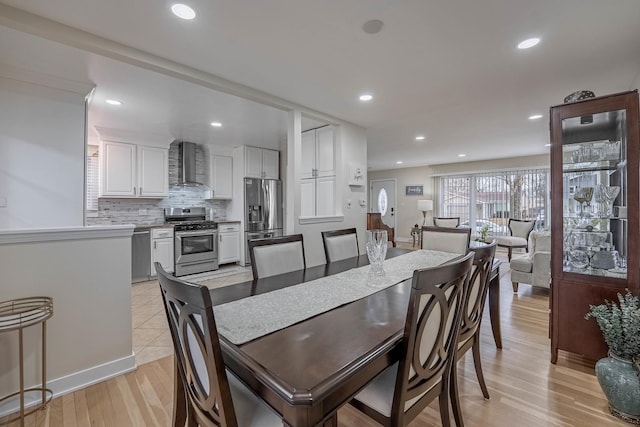 dining space featuring light wood-style flooring and recessed lighting