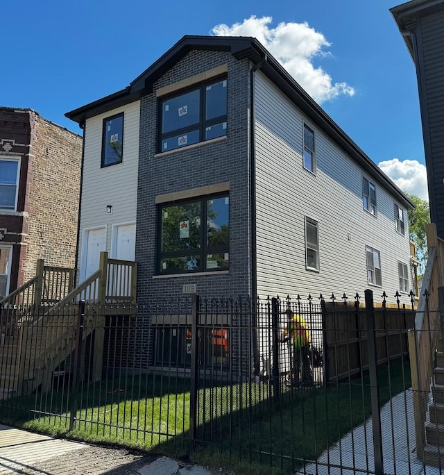 view of front of home featuring brick siding and a fenced front yard