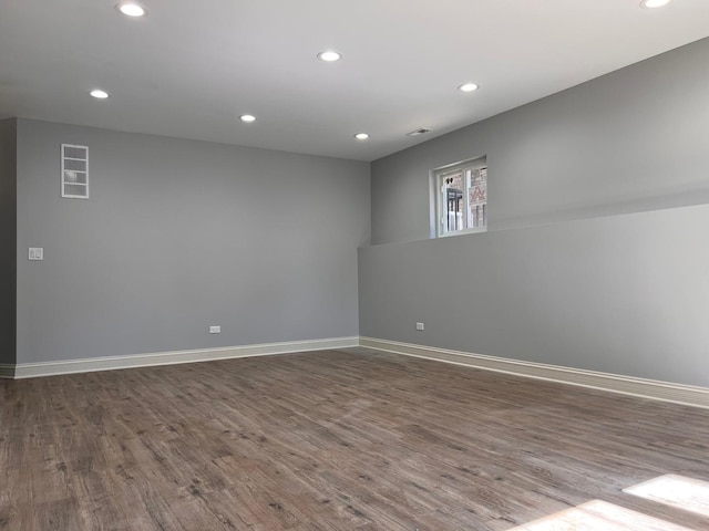 empty room featuring recessed lighting, dark wood finished floors, and baseboards