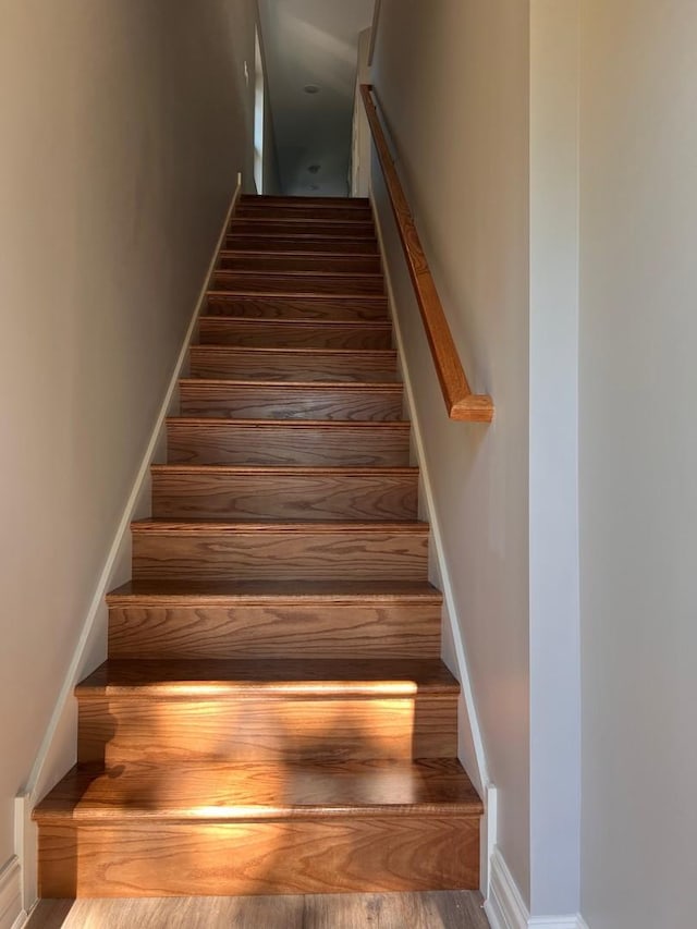 stairway with baseboards and wood finished floors