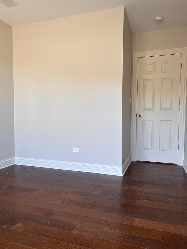 spare room with dark wood-style floors and baseboards