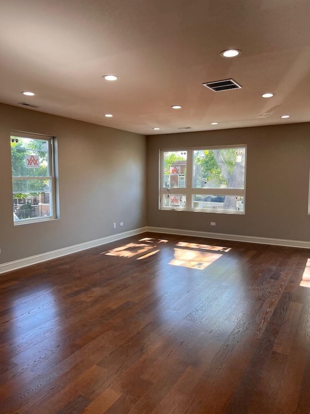 unfurnished room featuring dark wood-type flooring, recessed lighting, visible vents, and baseboards