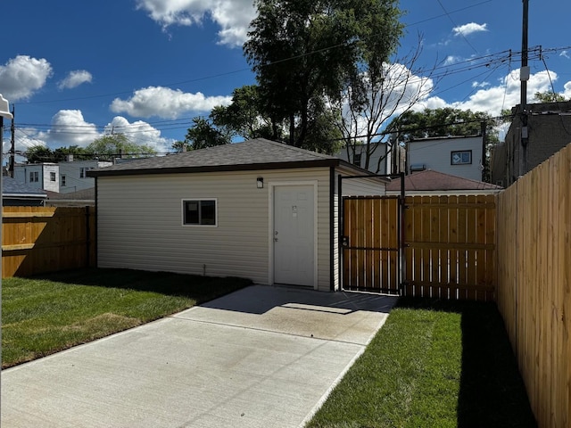 view of outdoor structure with a fenced backyard, a gate, and an outbuilding