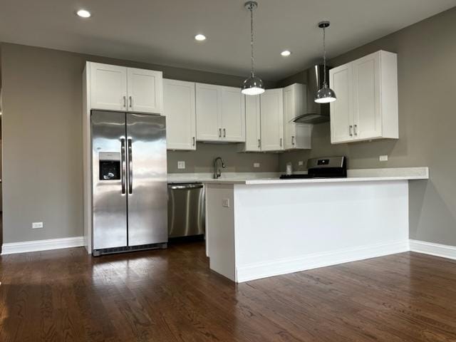 kitchen with wall chimney exhaust hood, a peninsula, stainless steel appliances, light countertops, and a sink