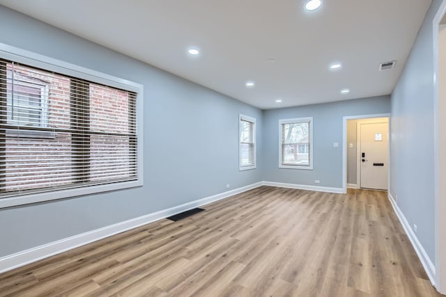 unfurnished room featuring baseboards, light wood-style floors, visible vents, and recessed lighting