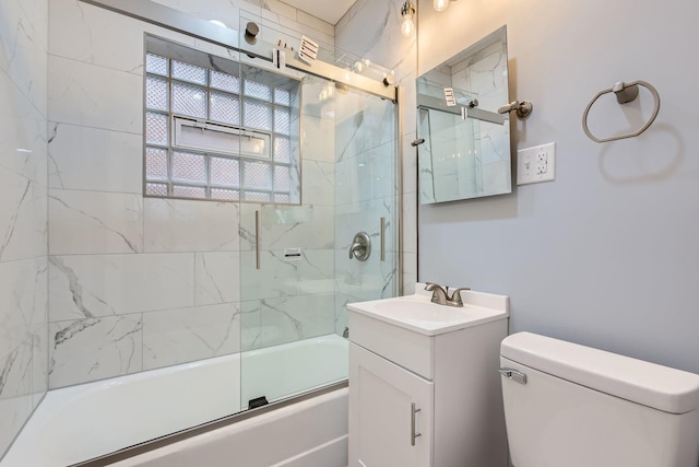 full bath with toilet, bath / shower combo with glass door, and vanity