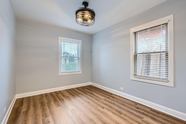 spare room featuring baseboards and wood finished floors