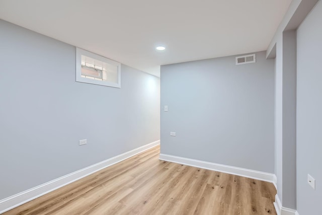 basement featuring baseboards, visible vents, and light wood-style flooring