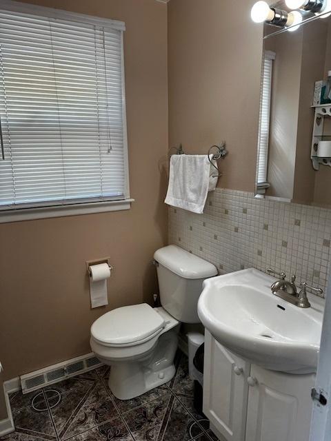 115 N Lavergne Ave, Northlake, IL 60164 - bathroom with toilet, tile patterned floors, decorative backsplash, and vanity
