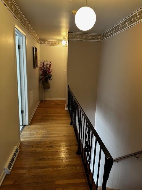 115 N Lavergne Ave, Northlake, IL 60164 - hallway with wood finished floors, baseboards, and an upstairs landing