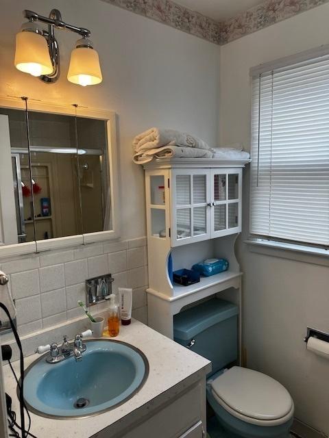 115 N Lavergne Ave, Northlake, IL 60164 - bathroom featuring toilet, tasteful backsplash, vanity, and a shower with door