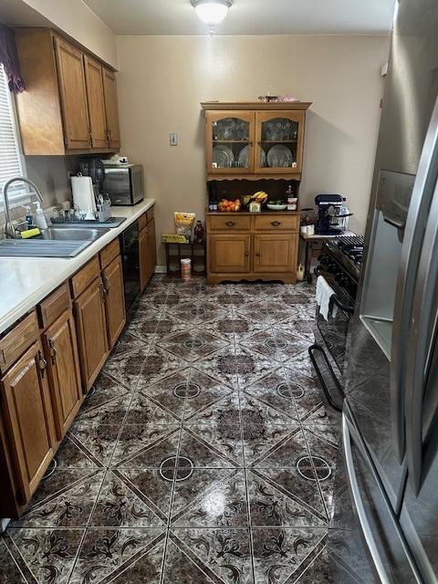 115 N Lavergne Ave, Northlake, IL 60164 - kitchen featuring a sink, brown cabinetry, dishwasher, glass insert cabinets, and light countertops