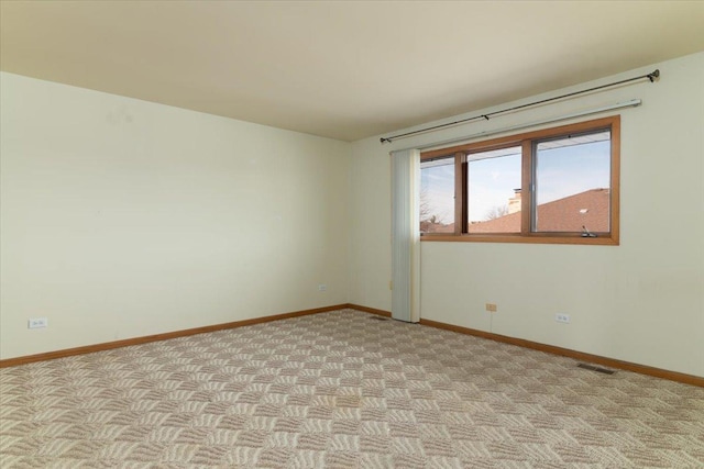 spare room with light colored carpet, visible vents, and baseboards