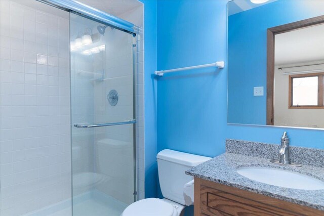 bathroom featuring a stall shower, vanity, and toilet