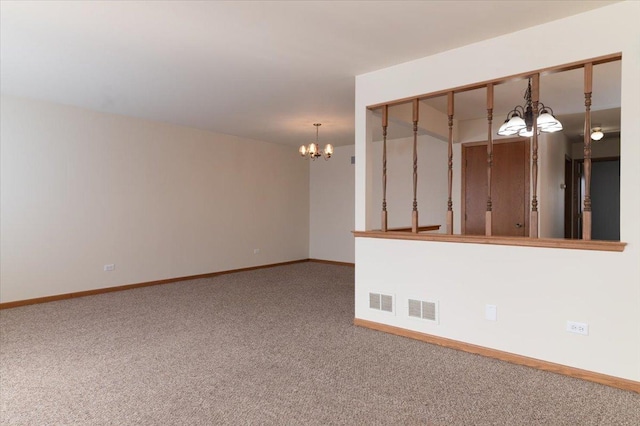 carpeted empty room featuring a chandelier, visible vents, and baseboards