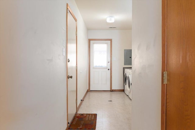 clothes washing area with laundry area, electric panel, baseboards, and light floors