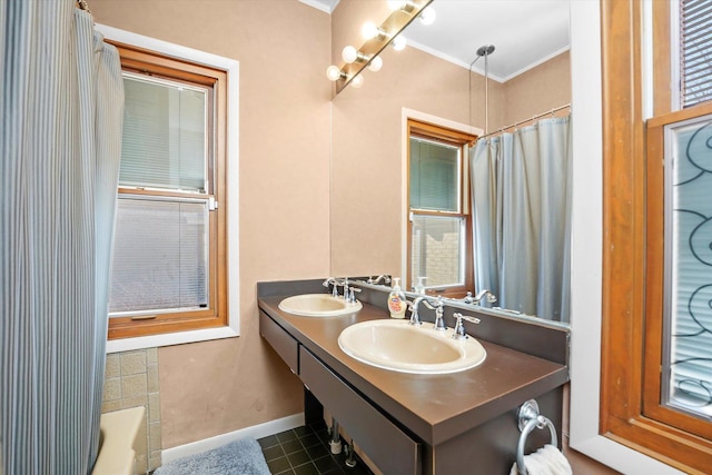 full bathroom featuring tile patterned floors, crown molding, baseboards, and a sink