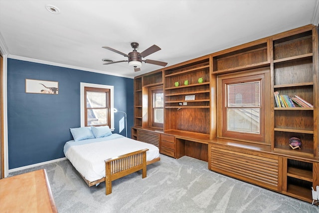 bedroom with carpet flooring, baseboards, built in desk, and ornamental molding