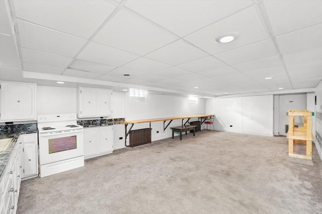 kitchen featuring white range with electric cooktop, dark countertops, white cabinetry, a paneled ceiling, and light colored carpet