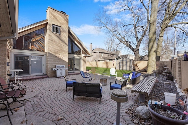 view of patio / terrace featuring a storage unit, an outdoor structure, area for grilling, and a fenced backyard