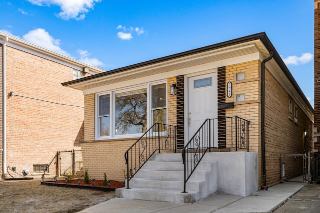 view of front of home with a gate and brick siding