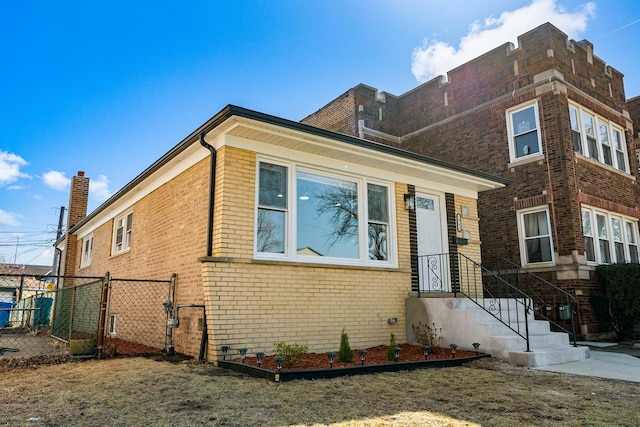 view of front facade with brick siding and fence