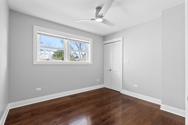 unfurnished bedroom with visible vents, dark wood-type flooring, ceiling fan, baseboards, and a closet