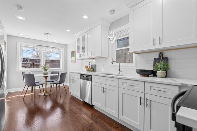 kitchen with dark wood-type flooring, a sink, stainless steel dishwasher, white cabinets, and range