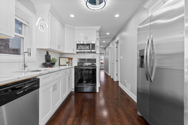 kitchen with a sink, light stone counters, tasteful backsplash, dark wood-style floors, and appliances with stainless steel finishes