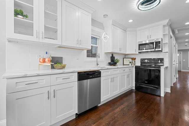 kitchen featuring glass insert cabinets, light stone countertops, appliances with stainless steel finishes, white cabinets, and dark wood-style flooring