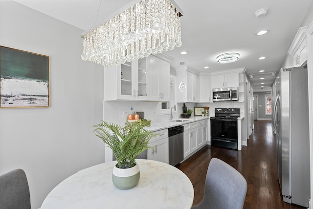 kitchen with a sink, appliances with stainless steel finishes, and white cabinets