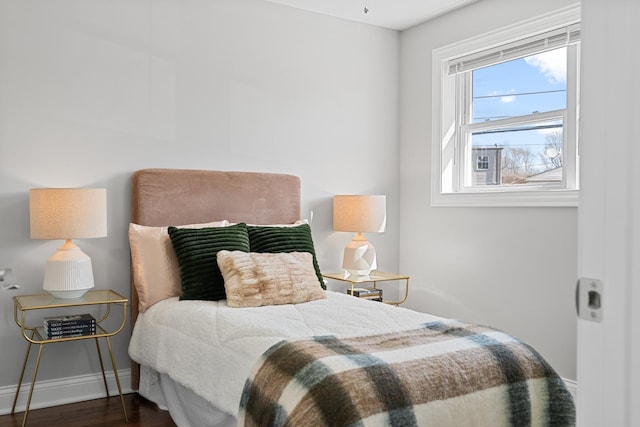 bedroom with baseboards and wood finished floors