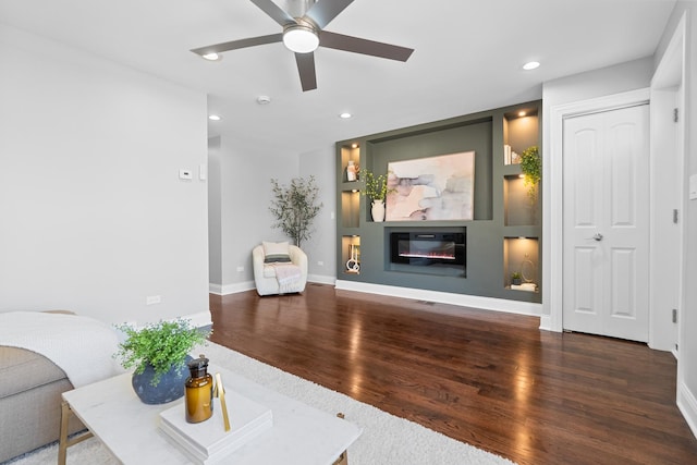 living room featuring recessed lighting, a glass covered fireplace, wood finished floors, and a ceiling fan