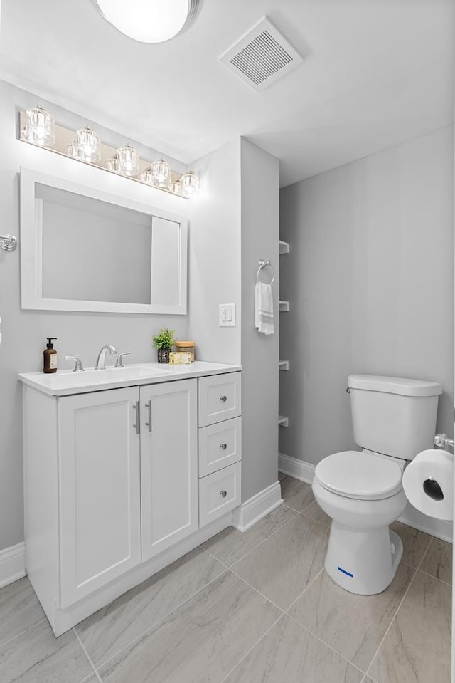 bathroom with vanity, toilet, baseboards, and visible vents