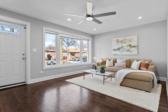 living area with dark wood-type flooring, a ceiling fan, and a wealth of natural light