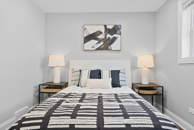 bedroom featuring baseboards and visible vents