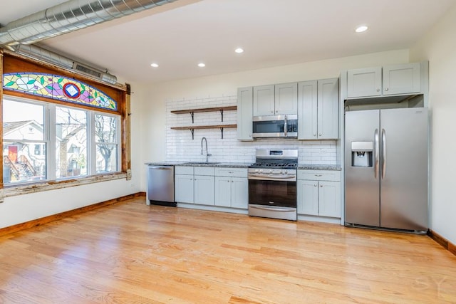 kitchen featuring a sink, open shelves, tasteful backsplash, and stainless steel appliances