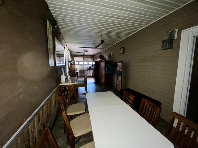 dining space featuring wood walls