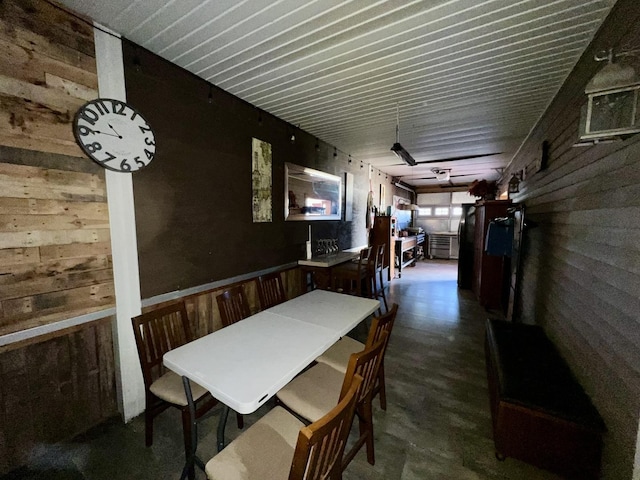 dining space featuring wood walls