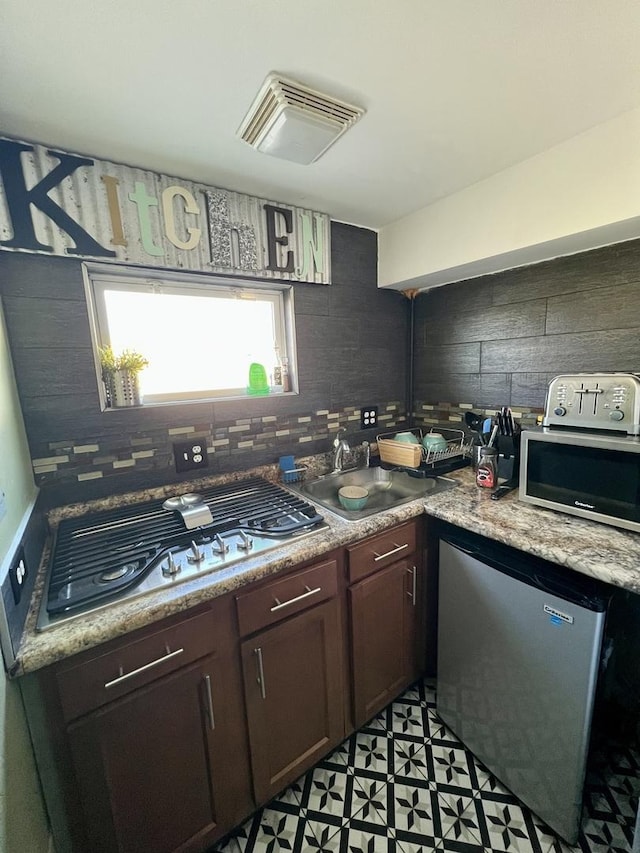 kitchen with visible vents, appliances with stainless steel finishes, decorative backsplash, and a sink