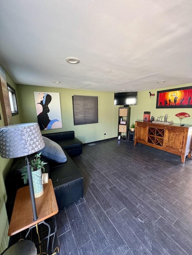 living room featuring baseboards, wood finished floors, and a dry bar