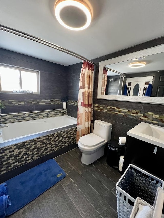 full bathroom featuring vanity, toilet, and tile walls